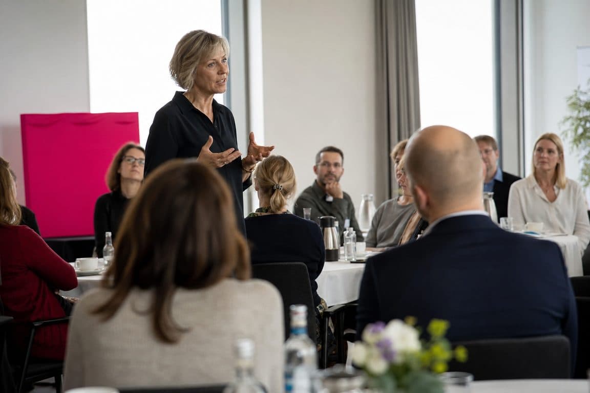 Unternehmerin spricht bei einem Business-Frühstück vor kleinem Publikum
