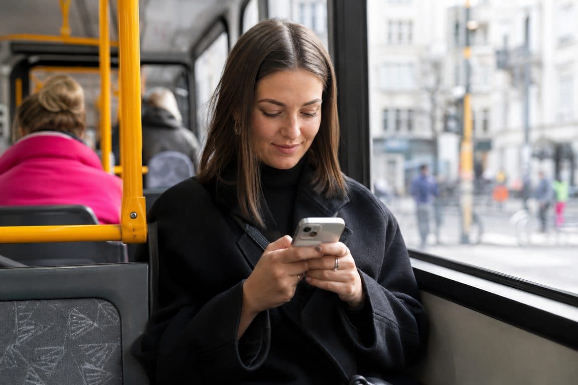 Frau beantwortet in der Straßenbahn Kommentare auf dem Handy
