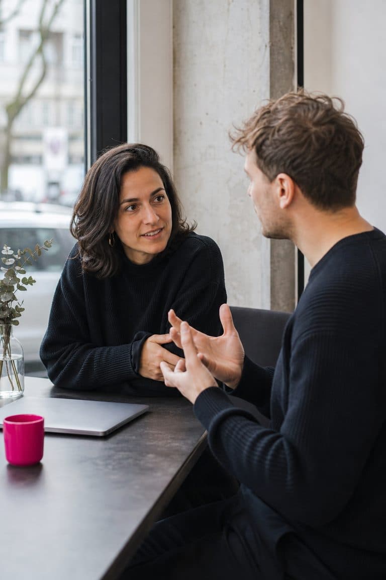 Café-Inhaber und Berater sprechen an einem Fenstertisch