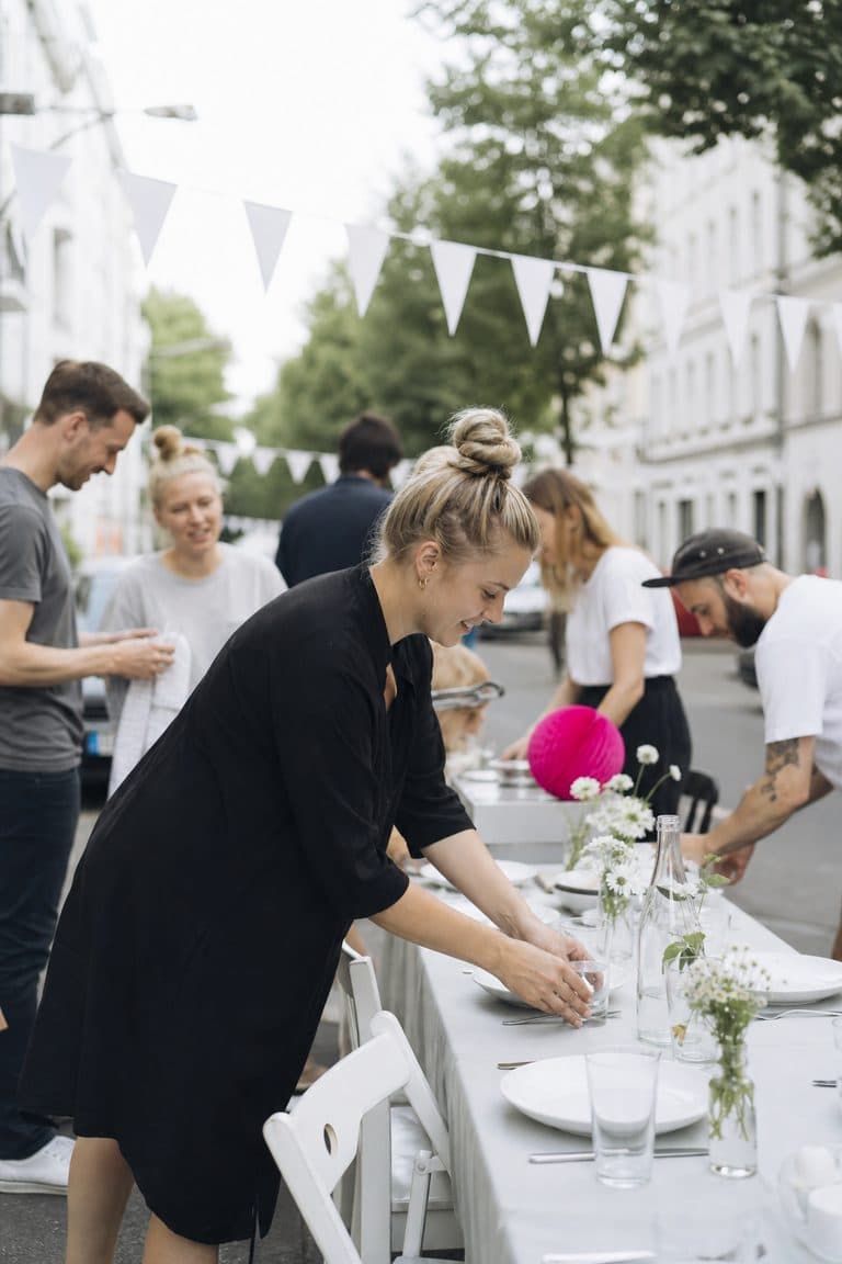 Nachbarn bauen Tische für ein Straßenfest im Kiez auf
