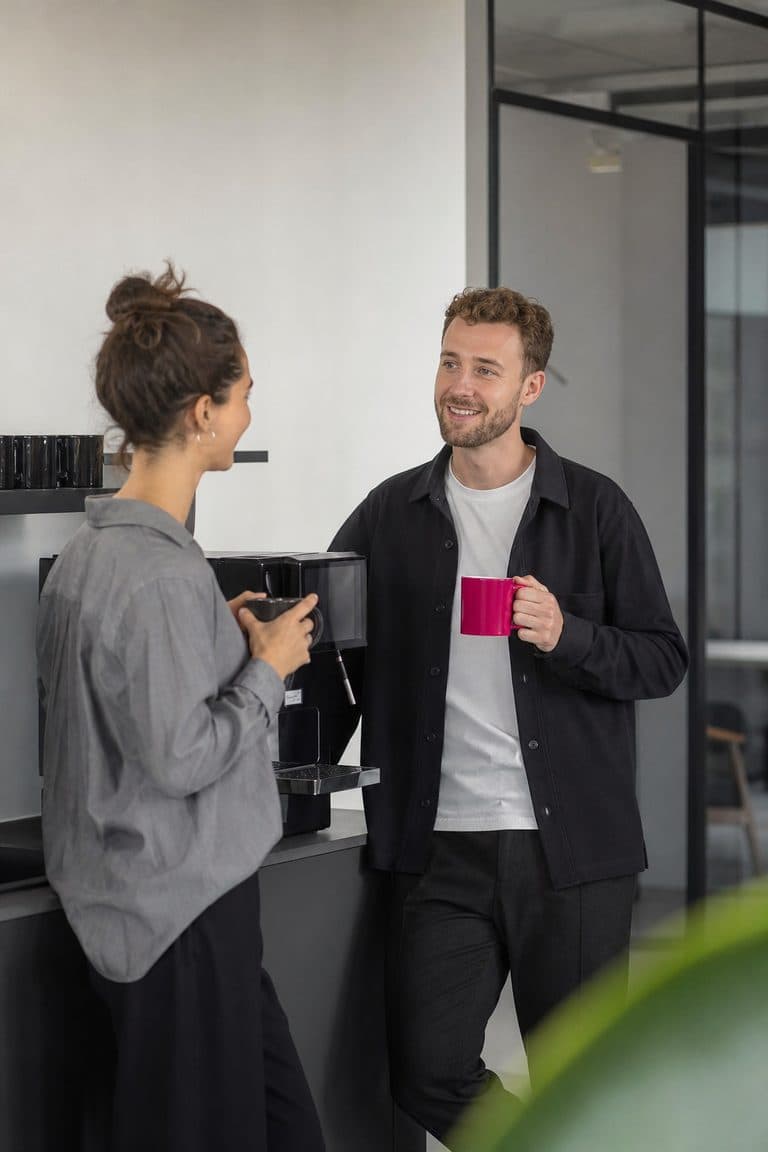 Zwei Kollegen sprechen an der Kaffeemaschine