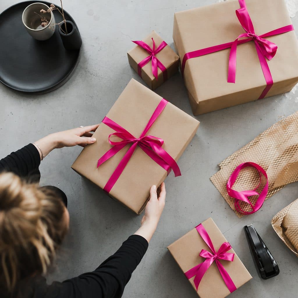 Pakete in Packpapier mit pinkem Band, bereit für den Versand
