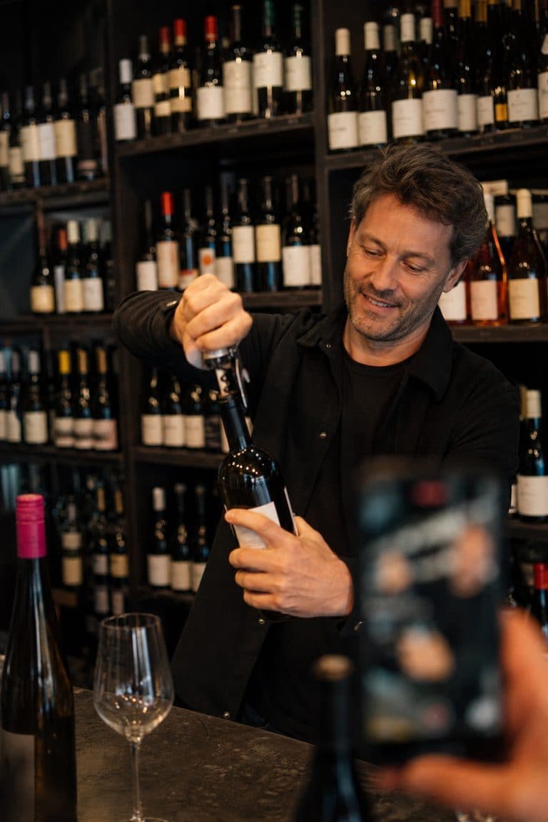 Weinhändler filmt für einen Clip, wie eine Flasche geöffnet wird
