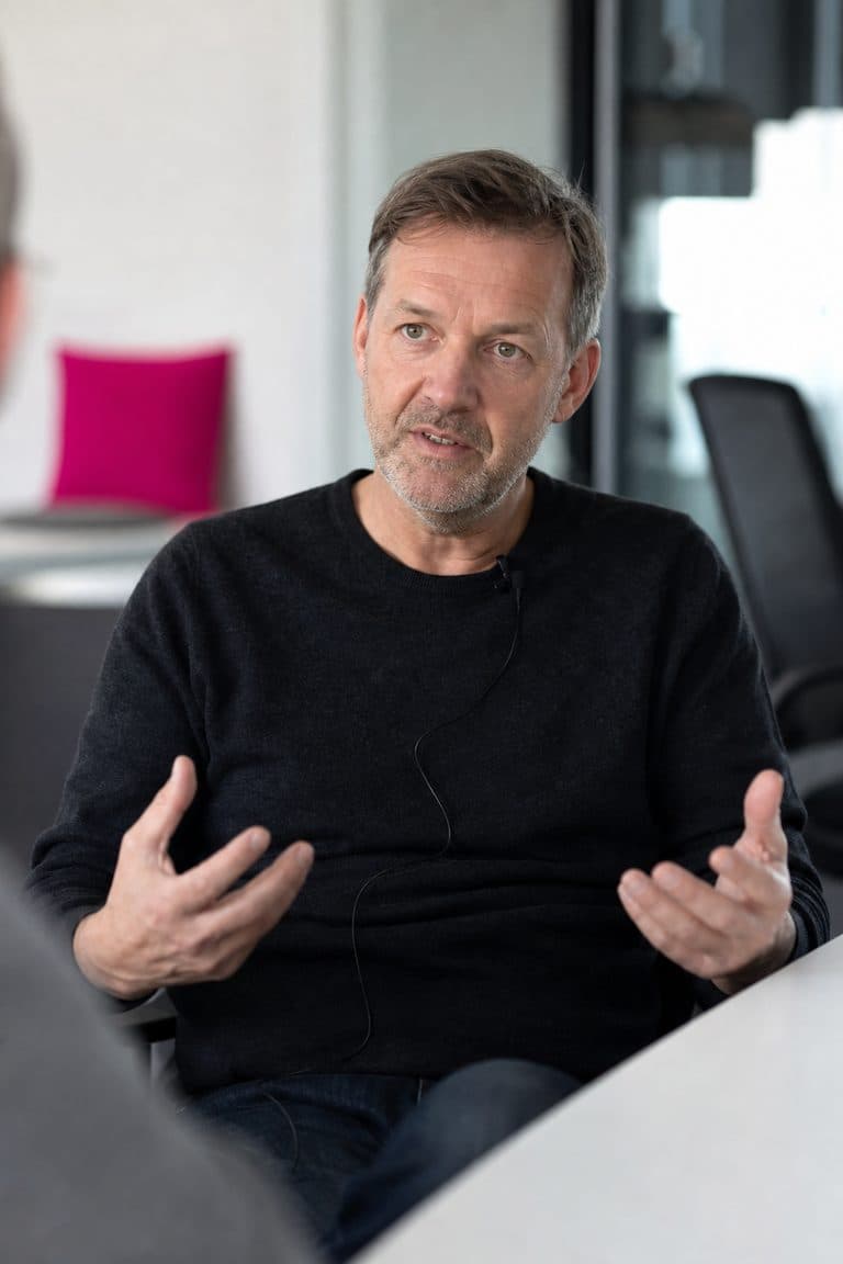 Mann gibt in einem Besprechungsraum ein Interview mit Ansteckmikrofon