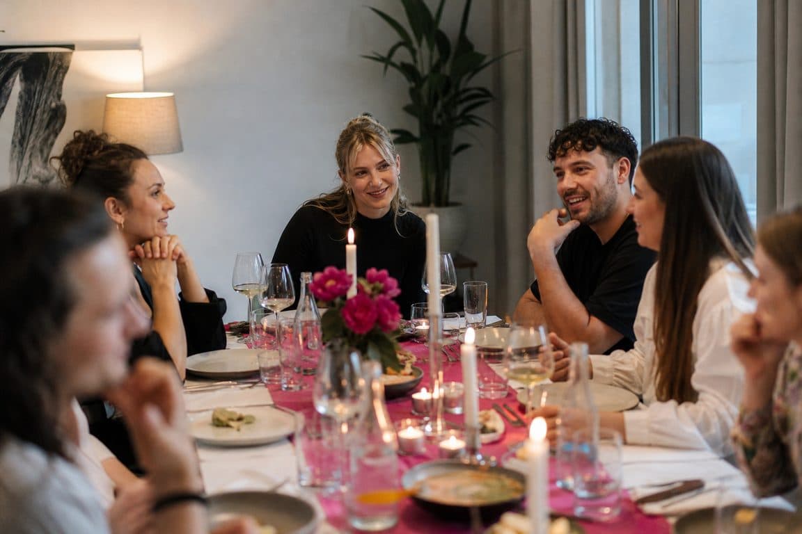 Gedeckter Tisch für Freunde mit Kerzen und pinkem Läufer