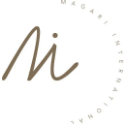 Logo mit der stilisierten Aufschrift "Mi" in Braun mit einem Kreis aus feinen Buchstaben, die um das große "Mi" herum angeordnet sind und Wörter wie "MAGARI" und "INTERNATIONAL" bilden.